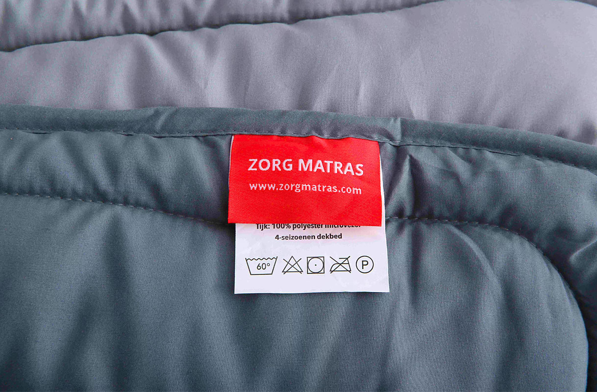 Waslabel op dekbed met wassymbolen en temperatuuraanduiding 60 graden