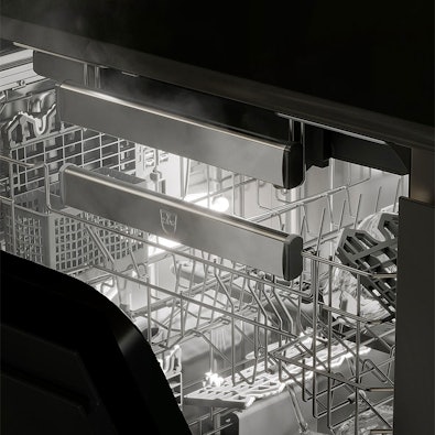 Close-up van V-ZUG Adora vaatwasserinterieur met SteamFinish, stoomdroging voor glanzende glazen en vlekvrij servies.