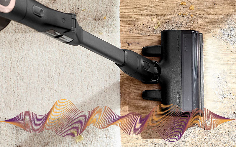 Steelstofzuiger zuigt kruimels op van harde vloer en kleed met geluidsniveau weergave – uitleg over variatie in decibelwaarden