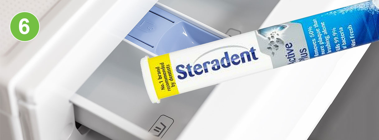 Steradent toevoegen aan wasmachine: verpakking Steradent kunstgebitreiniger wordt leeggeschud in het wasmiddelbakje