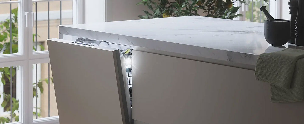 ATAG vaatwasser in een moderne open keuken met geopende deur, ontworpen voor een fluisterstille werking vanaf 38 dB.