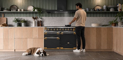 Stille recirculatie afzuigkap in open keuken met kokende man en slapende hond