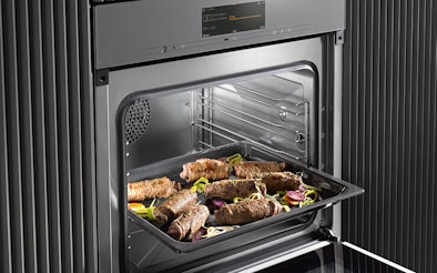 Inbouw combi-stoomoven met hetelucht en grill waarin een ovenschaal met gevulde vleesrolletjes wordt bereid.