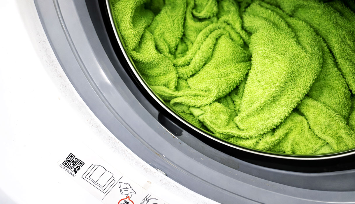 Bovenaanzicht van LG wasmachine trommel met nat wasgoed en waterdruppels die een lekkage suggereren