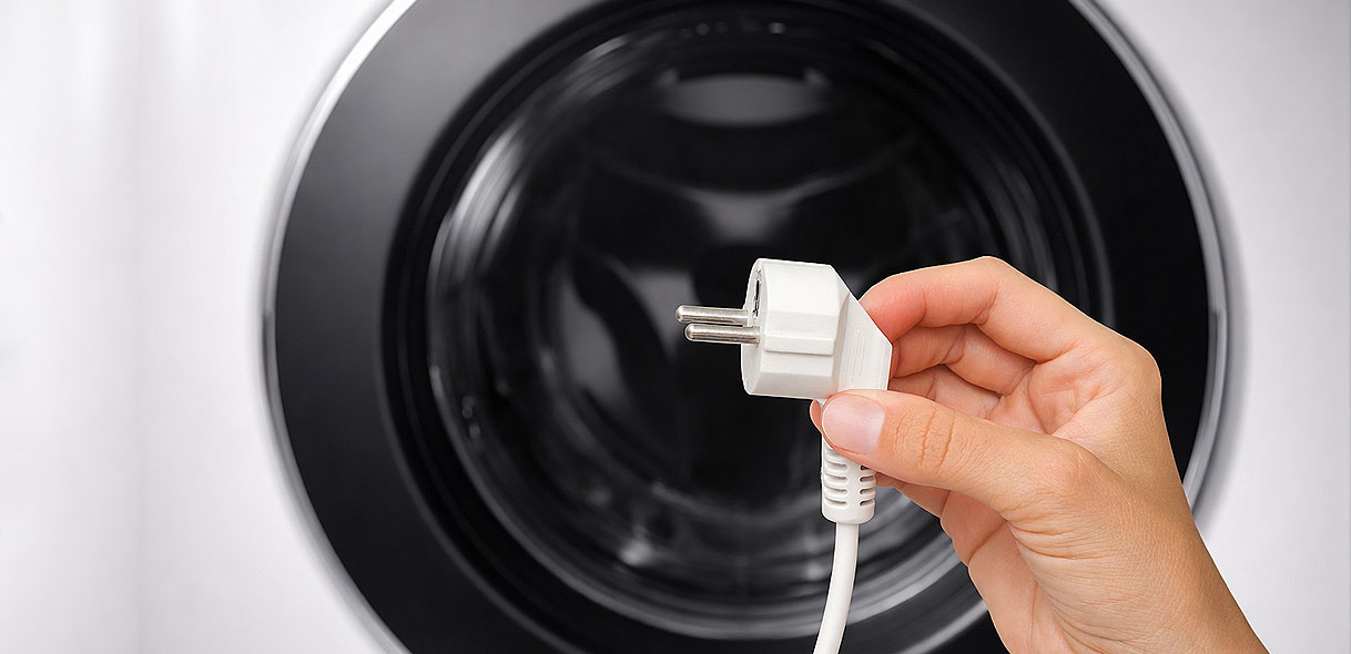 Losse stekker naast wasmachine die een stroomonderbreking als oorzaak van de PF storing toont