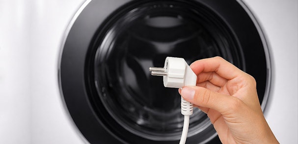 Losse stekker naast wasmachine die een stroomonderbreking als oorzaak van de PF storing toont