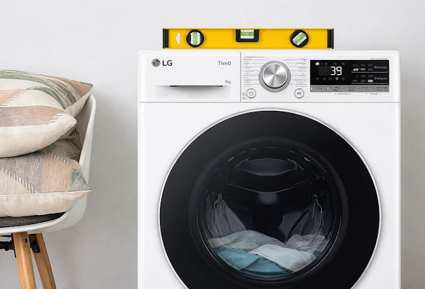 LG ThinQ wasmachine met waterpas op bovenkant die aangeeft dat de machine waterpas moet staan