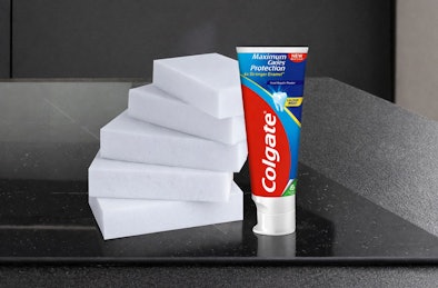 Wonderspons en tandpasta op inductie kookplaat voor verwijderen van hardnekkige vlekken