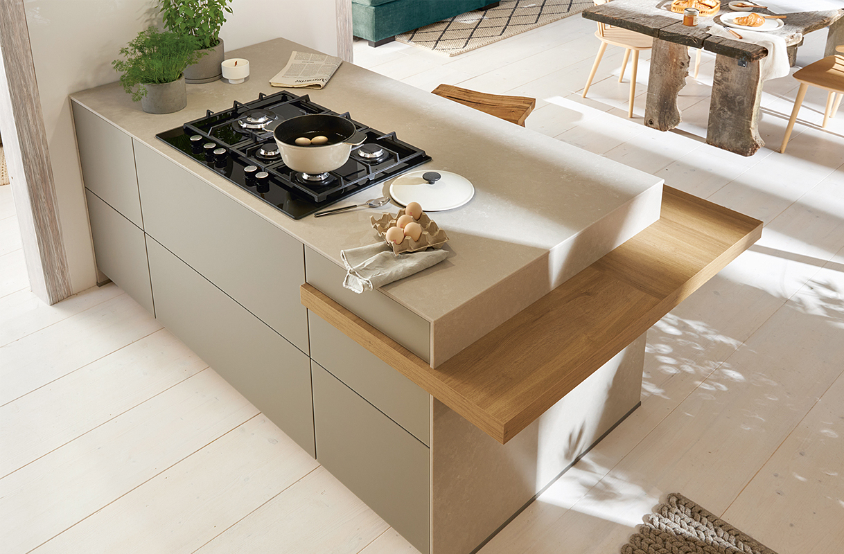 Taupe keukeneiland met een houten bar blad.