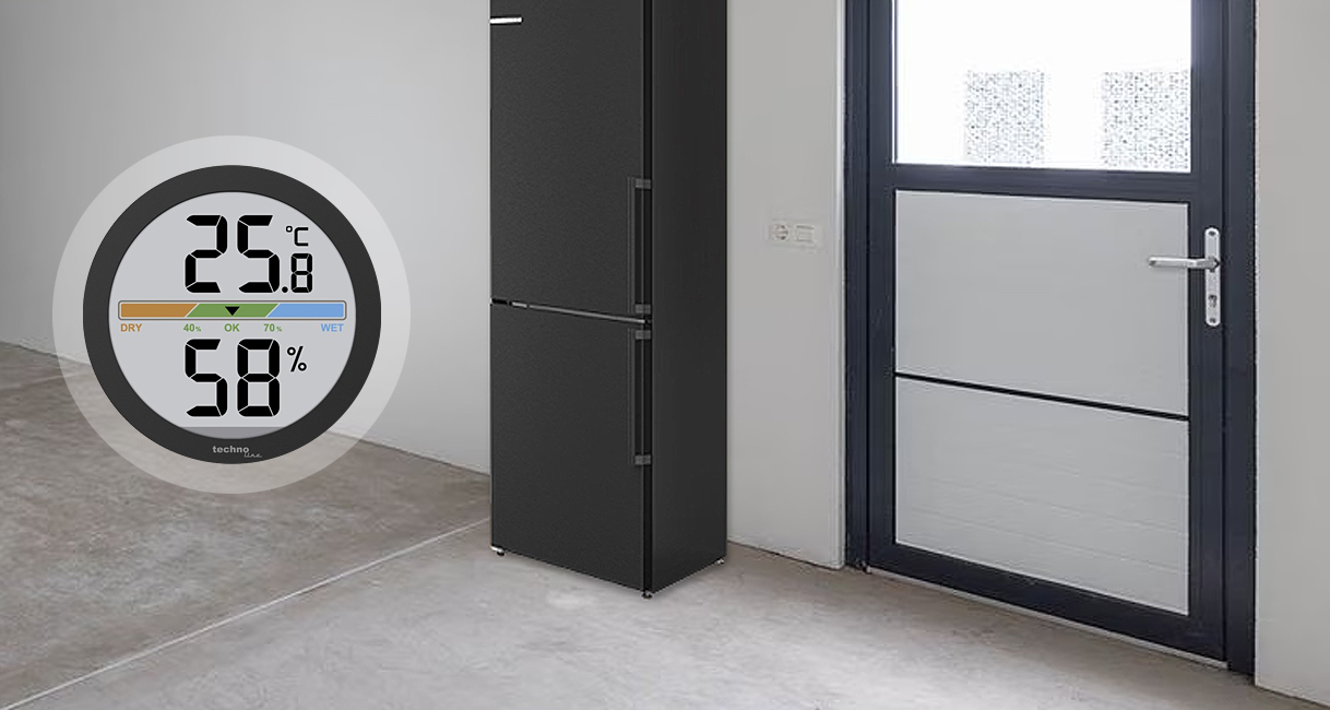 Digitale thermometer en hygrometer tonen temperatuur en luchtvochtigheid in een vorstvrije schuur met koelkast