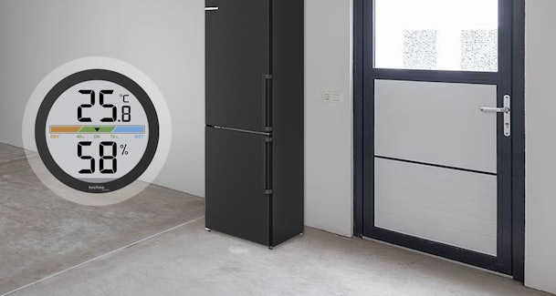 Digitale thermometer en hygrometer tonen temperatuur en luchtvochtigheid in een vorstvrije schuur met koelkast