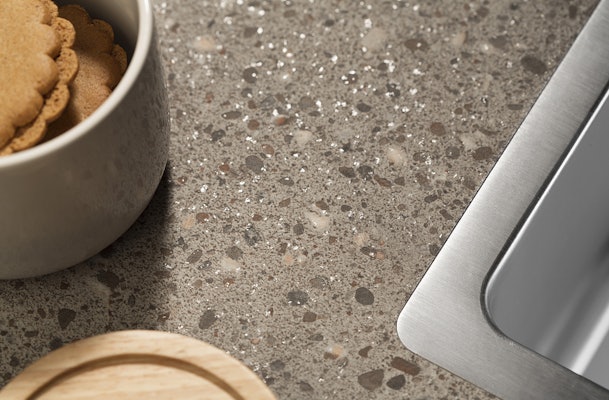 Een Terrazzo look aanrechtblad van kunststof is veel goedkoper dan een terrazzo keukenblad.