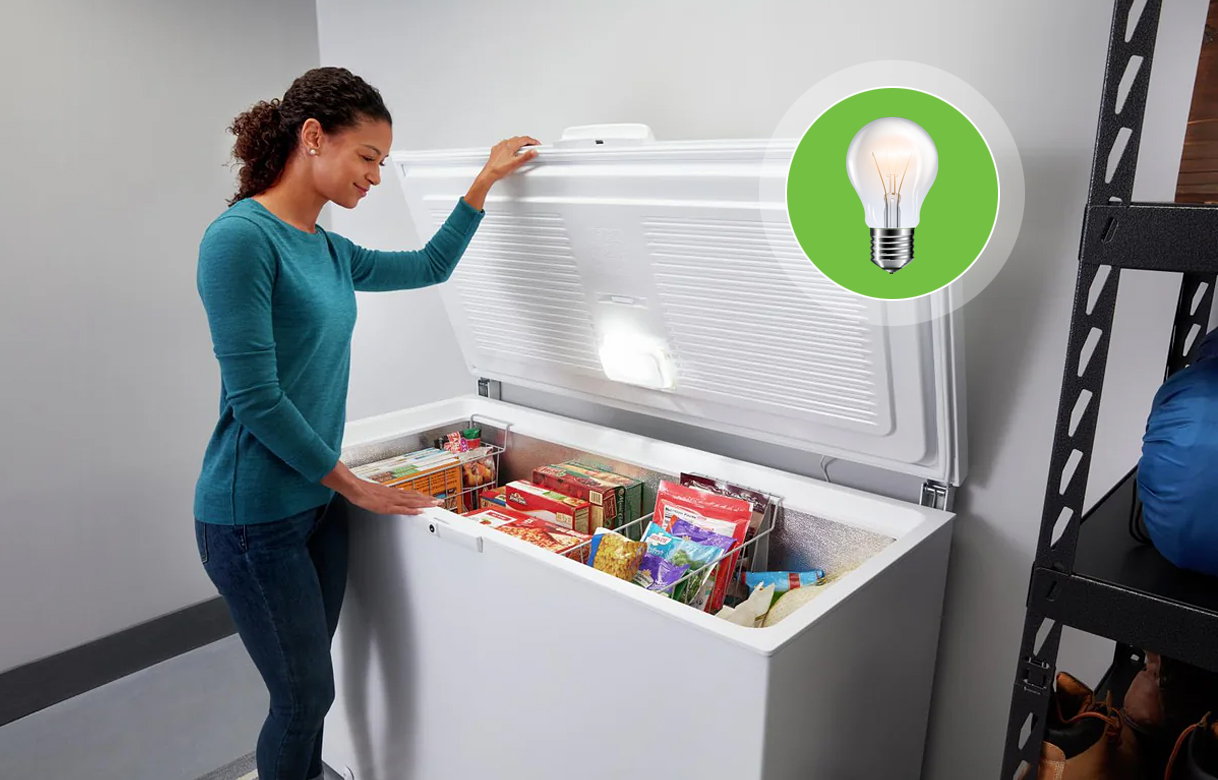 Vrouw bekijkt ingevroren producten in een goed geplaatste vrieskist in de schuur, met verlichting en ruimte rondom voor ventilatie.