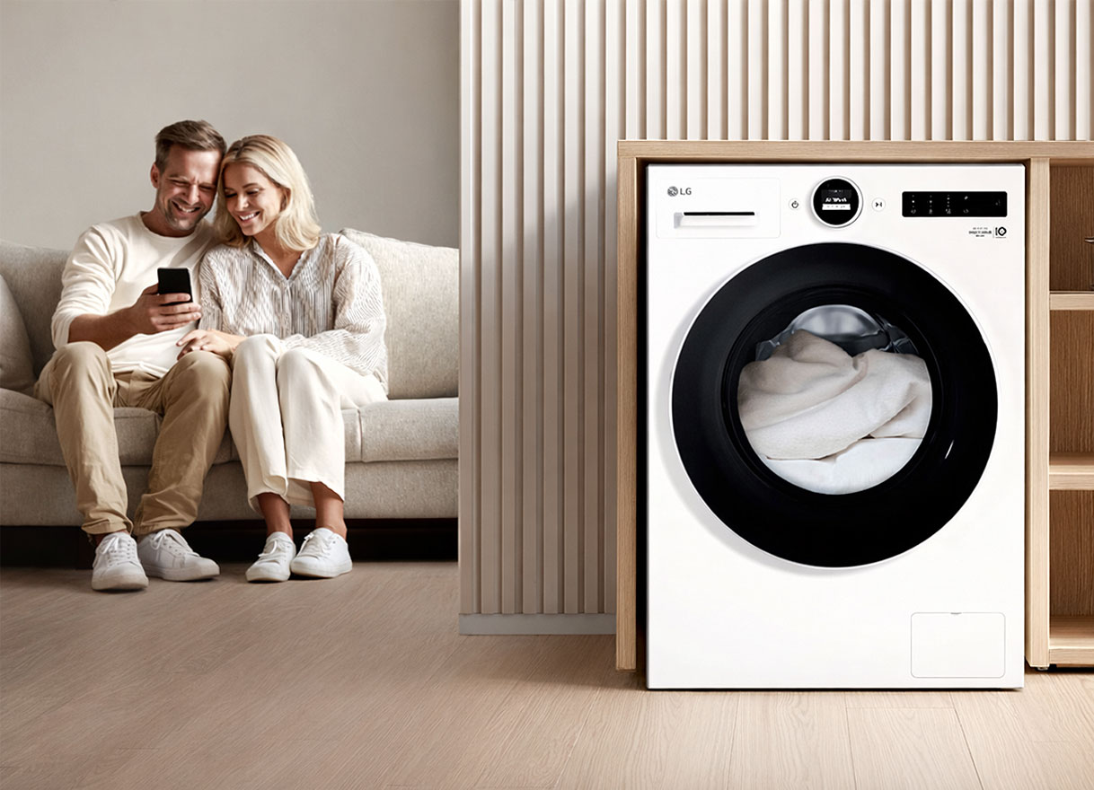 Vrouw bedient LG wasmachine op afstand via smartphone met ThinQ app in moderne woonkamer