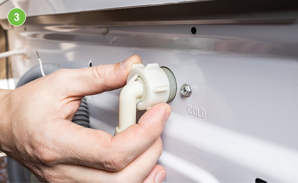 Toevoerslang loskoppelen van de achterkant van een wasmachine bij de wateraansluiting