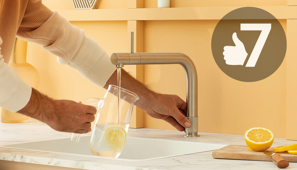 Man vult kan met water uit Quooker kraan met duim-omhoog icoon en cijfer 7