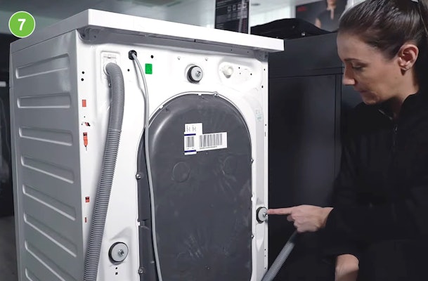 Transportbout wordt vastgedraaid aan de achterkant van een wasmachine