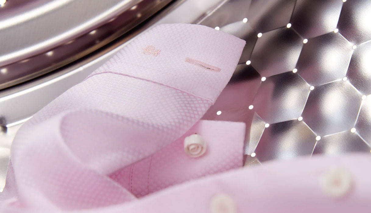 Roze overhemd in wasmachine trommel met honingraatstructuur