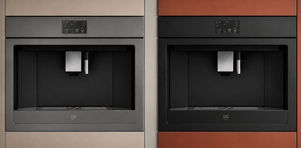 Twee modellen V-ZUG koffiemachines uit de V6000 serie naast elkaar ingebouwd in een keukenwand