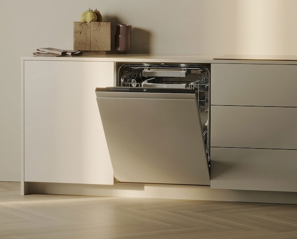 V-ZUG Adora inbouwvaatwasser met open deur in een minimalistische keuken, ruim interieur met korven en besteklade, warm LED-licht voor optimale zichtbaarheid.