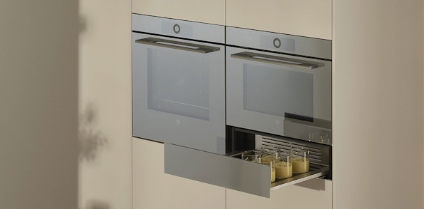Waarom kiezen voor een V-ZUG warmhoudlade? V-ZUG warmhoudlades vertegenwoordigen de absolute top in keukenapparatuur uit Zwitserland. Deze premium lades transformeren jouw keuken tot een professionele werkruimte waar culinaire perfectie centraal staat. Met hun elegante spiegelglas design en geavanceerde TouchControl-bediening brengen ze zowel functionaliteit als stijl naar jouw keuken. De warmhoudlades van V-ZUG gaan verder dan alleen warmhouden. Ze vormen een complete culinaire oplossing die jouw manier van koken revolutioneert. Of je nu een ervaren thuiskok bent of iemand die graag experimenteert in de keuken, deze apparaten bieden de precisie en betrouwbaarheid die je nodig hebt voor consistente resultaten.