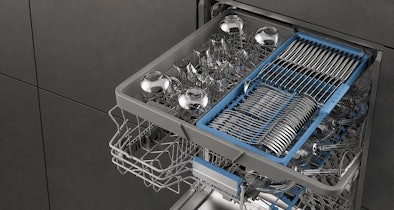 Bovenste besteklade van een Beko vaatwasser naast glazen in de bovenkorf