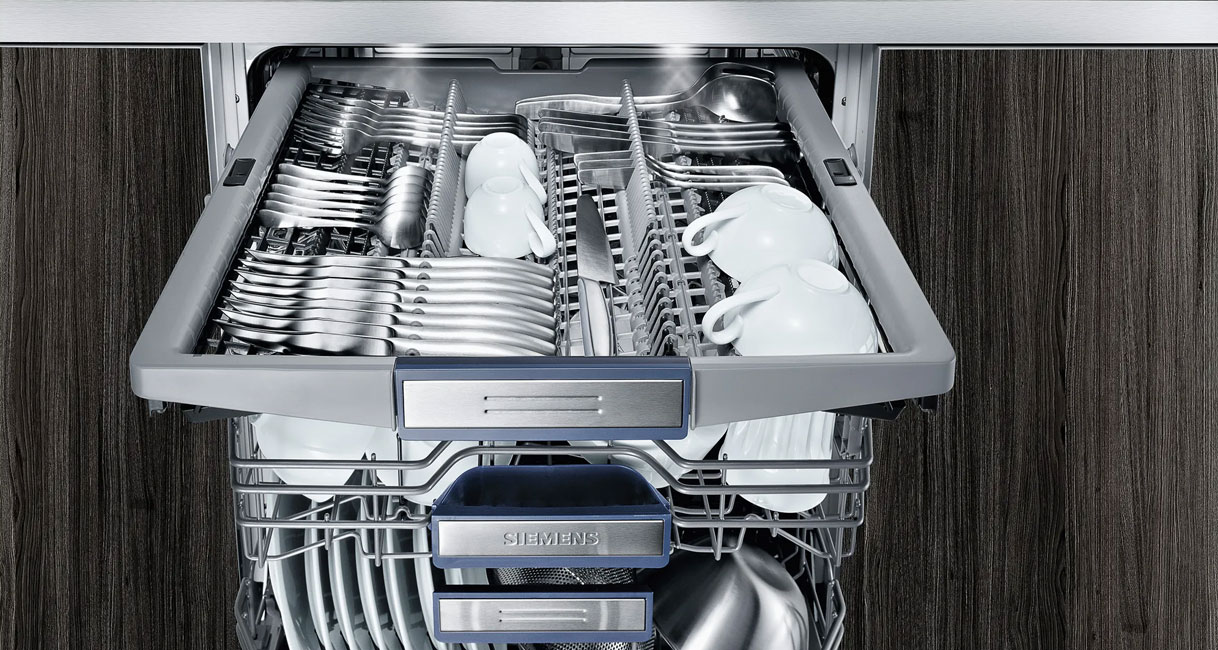 Bovenste besteklade van een Siemens vaatwasser met bestek en kopjes in aparte sleuven
