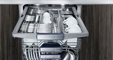 Bovenste besteklade van een Siemens vaatwasser met bestek en kopjes in aparte sleuven