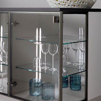 Verlichte vitrineeiland met glazen planken en LED.