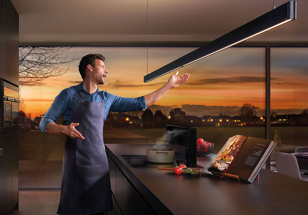 Kookeiland met hanglamp en heldere verlichting tijdens koken voor goed zicht en sfeer