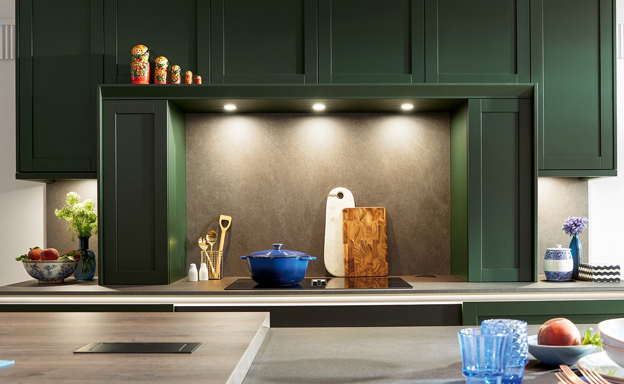 Verlichting onder groene keukenkastjes