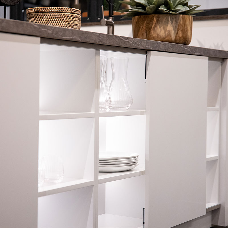 Verlichtte open kasten aan de voorzijde van het kookeiland