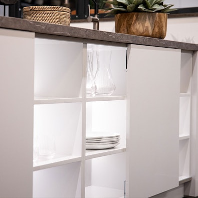 Verlichtte open kasten aan de voorzijde van het kookeiland