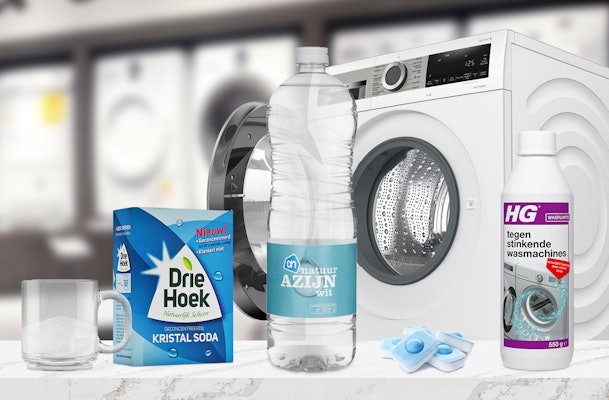 Reinigingsmiddelen tegen vetluis: doos Driehoek kristalsoda, fles AH natuurazijn, vaatwastabletten en HG wasmachinereiniger voor een wasmachine