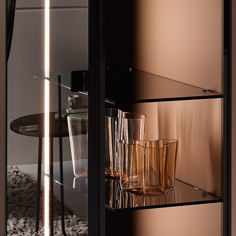 Vitrinekast met glazen planken en warme verlichting.