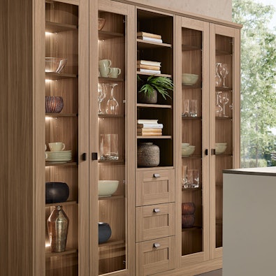 Houten vitrinekast met glazen deuren en verlichting.