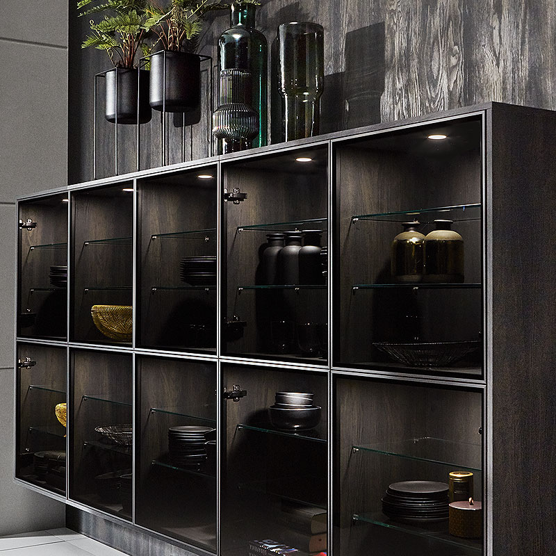 Zwevende vitrinekast in Parsol grijs met spots op blackwood wand.