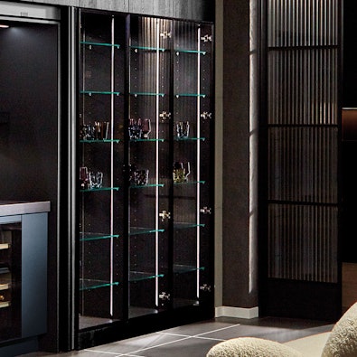 Verlichte vitrinekast met glazen planken.