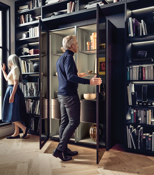 De vitrinekast ingebed in een reeks hoge kasten in de woonkamer.