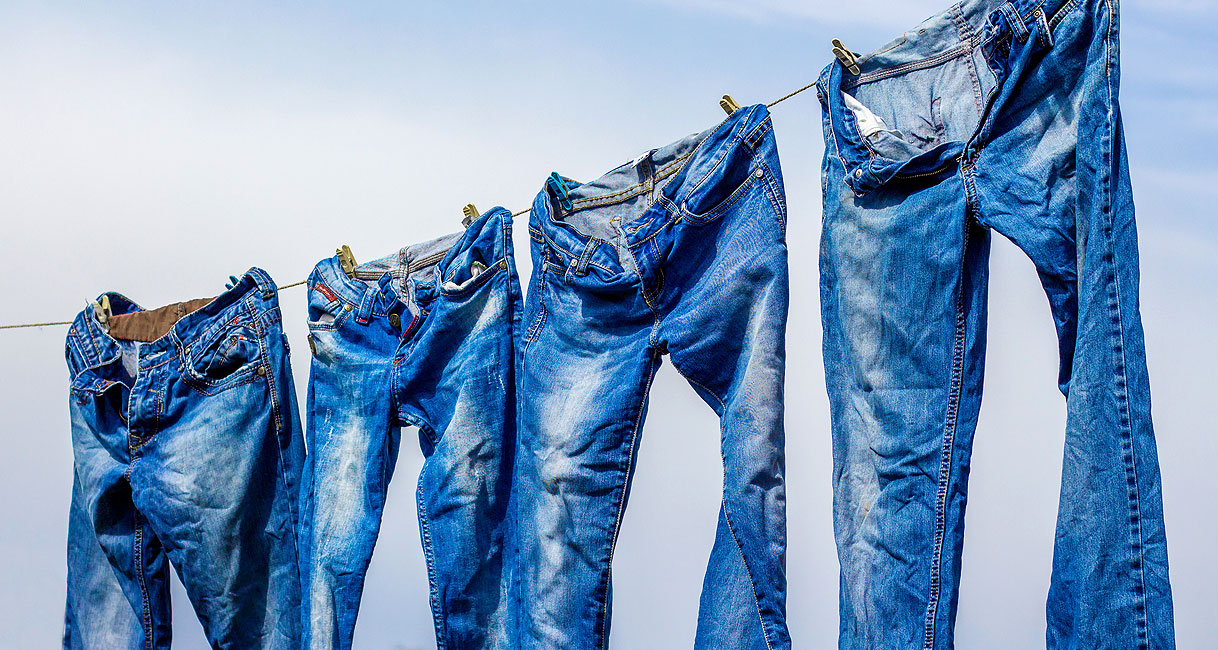 Jeans hangend aan waslijn met aandacht voor krimp pasvorm en kleurbehoud bij drogen