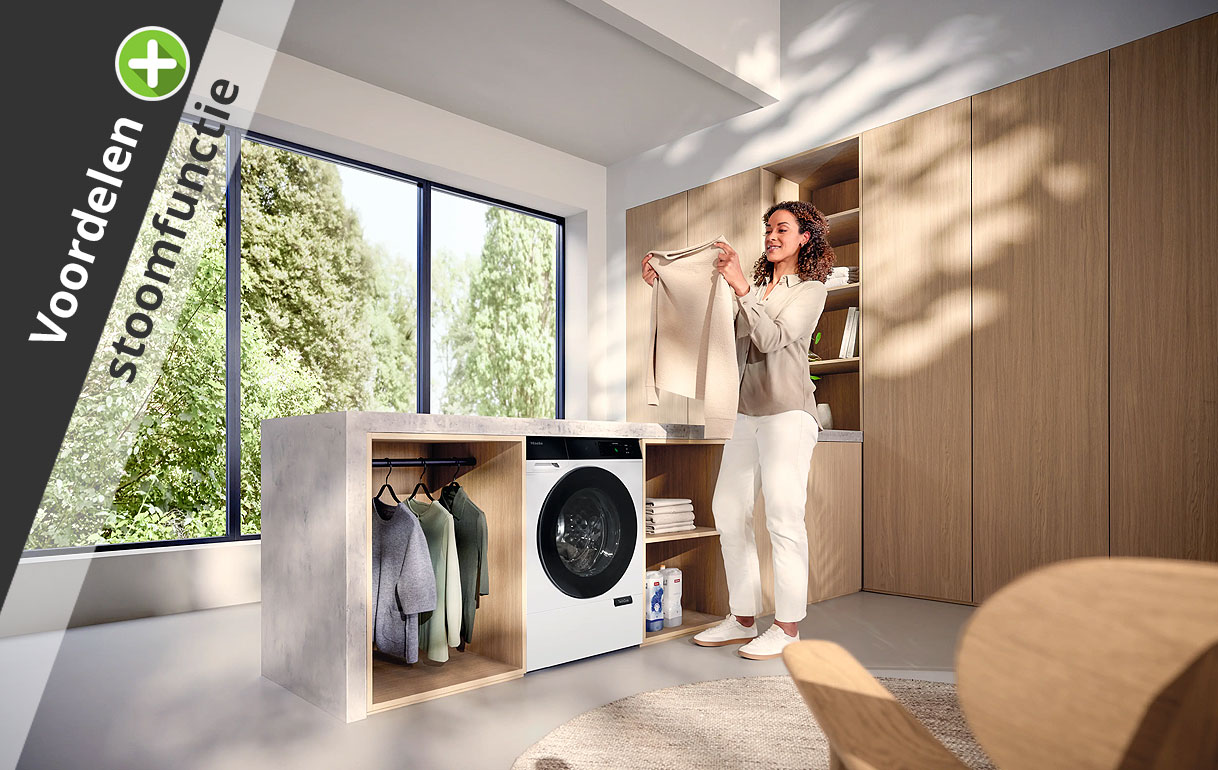 Vrouw in wasruimte met wasdroger als illustratie bij de voordelen van een droger met stoomfunctie
