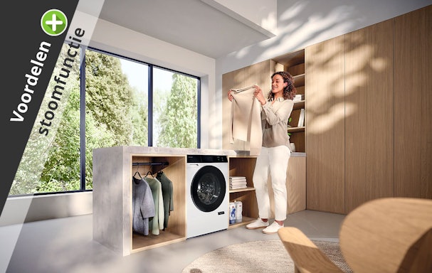 Vrouw in wasruimte met wasdroger als illustratie bij de voordelen van een droger met stoomfunctie