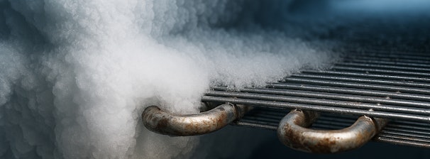 Bevroren vriezerleidingen met dikke ijslaag op metalen verdampers
