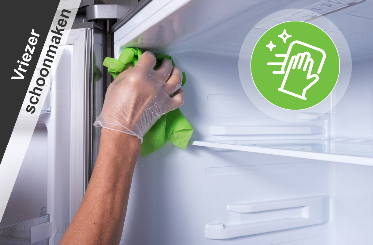 Hand reinigt binnenkant van een vriezer met een doek tijdens periodiek schoonmaken