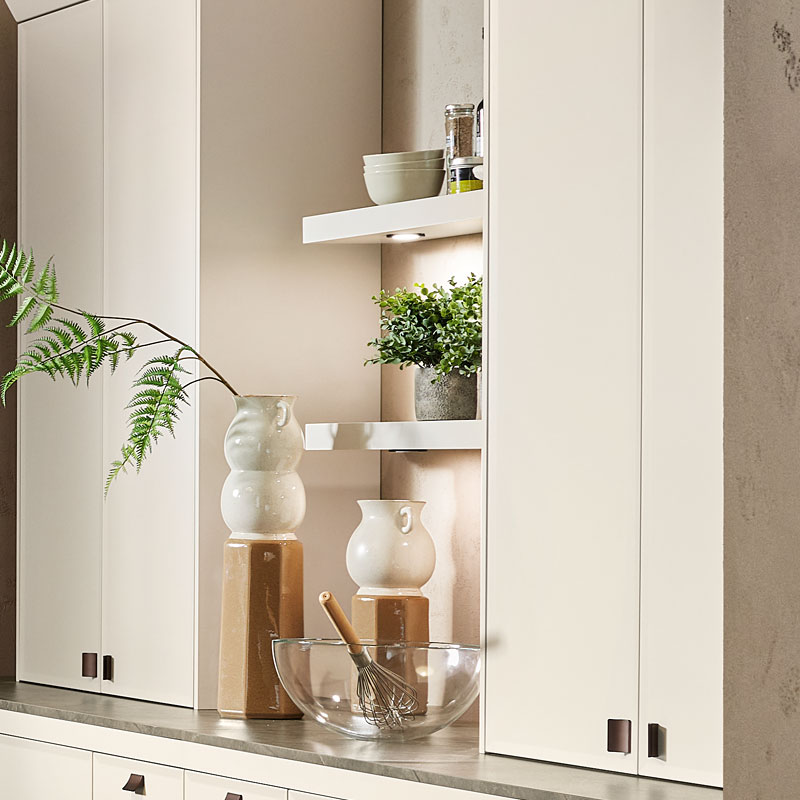 Wandkast met open vakken en verlichting.