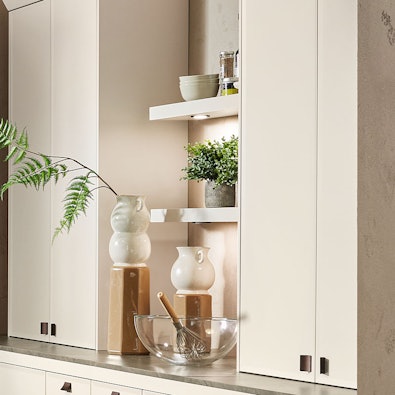 Wandkast met open vakken en verlichting.