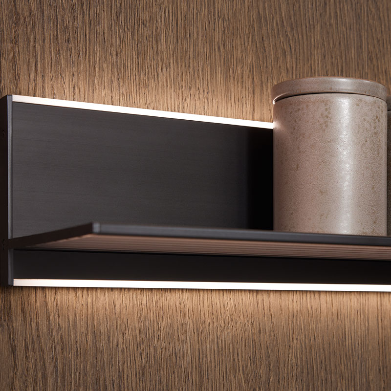 Verlichte wandplank op houtstructuur achterwand.