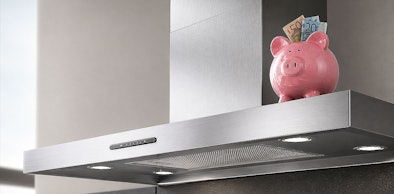 Wandschouw afzuigkap met zuinige energieklasse en spaarvarken met geld erop