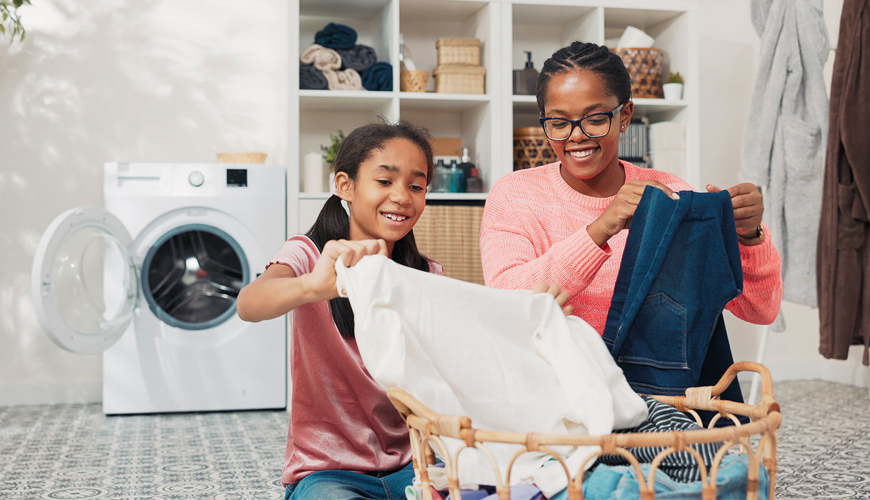 Moeder en dochter sorteren samen de was bij een wasmand