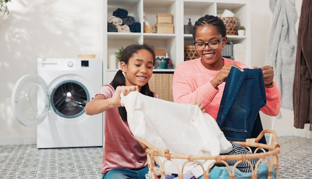 Moeder en dochter sorteren samen de was bij een wasmand